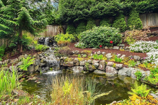view of yard with a small pond and fence