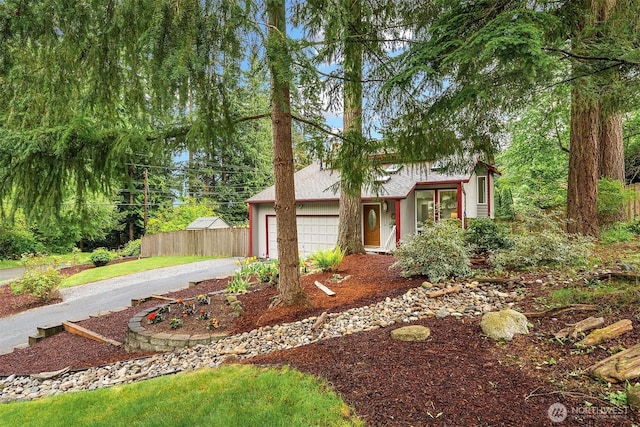 view of front facade featuring a garage, fence, and driveway