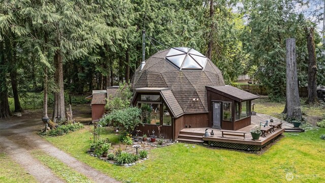 back of property featuring a lawn, a wooden deck, and roof with shingles