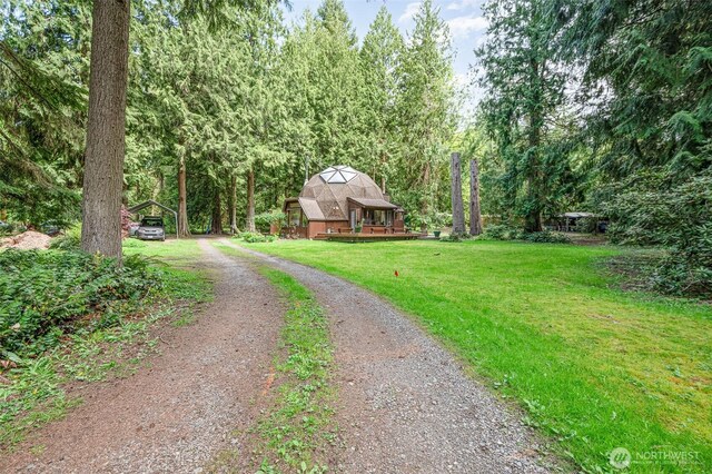 view of road featuring a view of trees and driveway