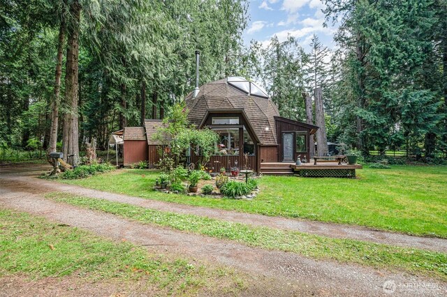 view of front of home with a deck and a front yard