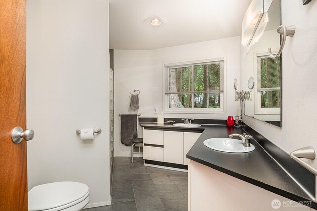 bathroom featuring vanity, baseboards, and toilet