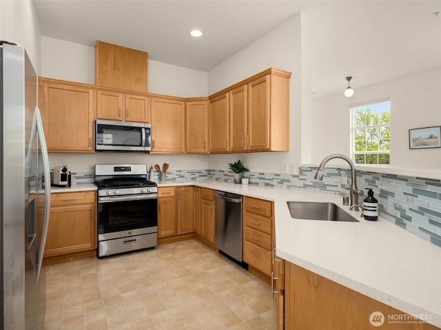kitchen featuring light countertops, a sink, decorative backsplash, and stainless steel appliances