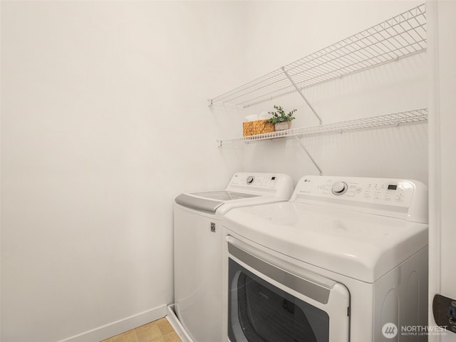 laundry room with laundry area, washer and clothes dryer, and baseboards