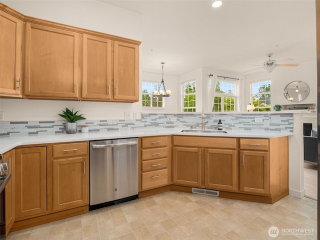 kitchen with backsplash, visible vents, dishwasher, a sink, and a peninsula