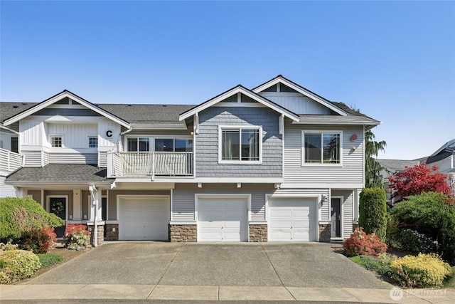 15720 Manor Way Unit C5, Lynnwood, WA 98087 - view of front of house with a garage, driveway, a balcony, stone siding, and board and batten siding