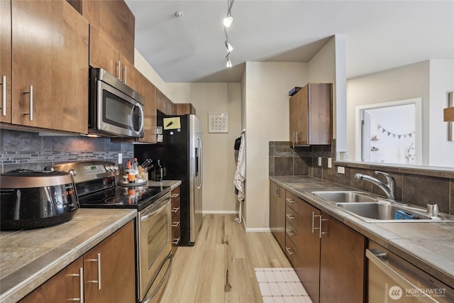 15720 Manor Way Unit C5, Lynnwood, WA 98087 - kitchen featuring stainless steel appliances, a sink, light wood-style flooring, and backsplash