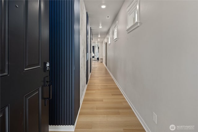 corridor with baseboards, recessed lighting, and light wood-type flooring