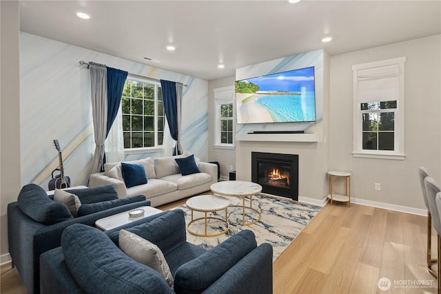 living area featuring recessed lighting, baseboards, wood finished floors, and a fireplace