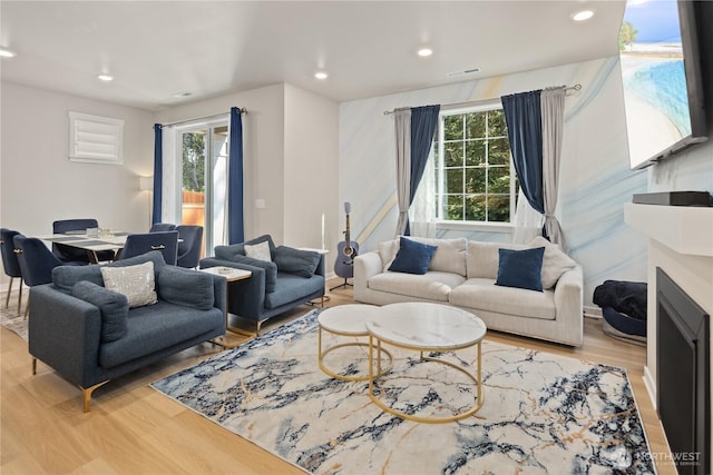 living room with plenty of natural light, recessed lighting, wood finished floors, and visible vents