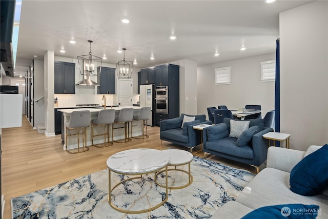 living area with recessed lighting, a chandelier, and light wood-style floors