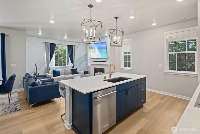 kitchen featuring visible vents, a sink, dishwasher, and light wood-type flooring