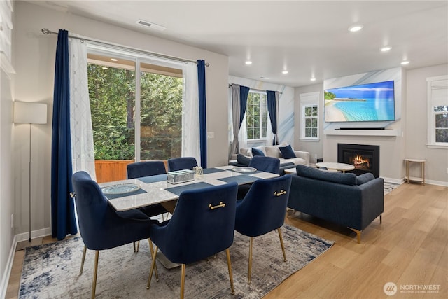 dining space with recessed lighting, visible vents, light wood-style flooring, and a fireplace