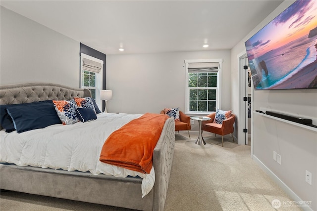 bedroom with recessed lighting, baseboards, multiple windows, and light carpet