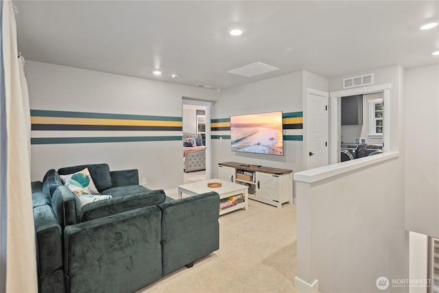 carpeted living room featuring visible vents, recessed lighting, and washing machine and clothes dryer