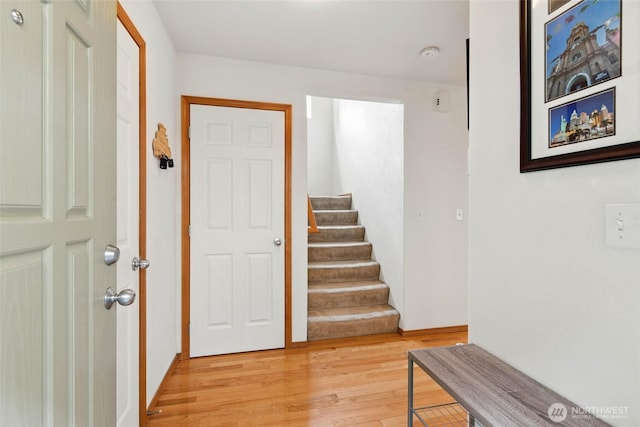 entryway with light wood-type flooring and stairs