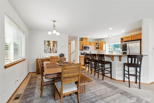 dining space with visible vents, baseboards, and an inviting chandelier