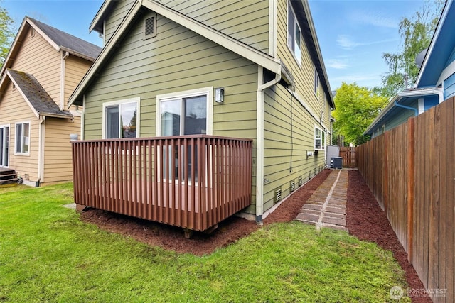 view of side of property with a lawn, central AC, fence, and a wooden deck