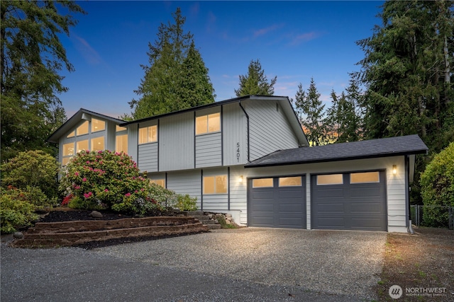 raised ranch with driveway and a garage