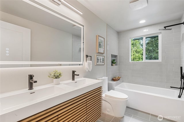 bathroom featuring a sink, recessed lighting, toilet, and double vanity