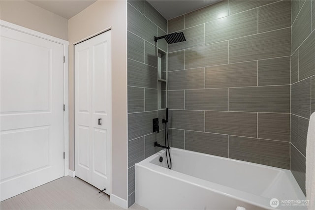 bathroom featuring baseboards, tile patterned flooring, and tiled shower / bath combo