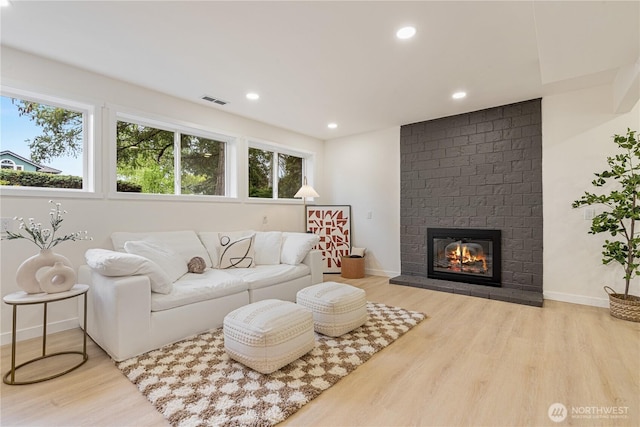 living area featuring a healthy amount of sunlight, wood finished floors, and visible vents