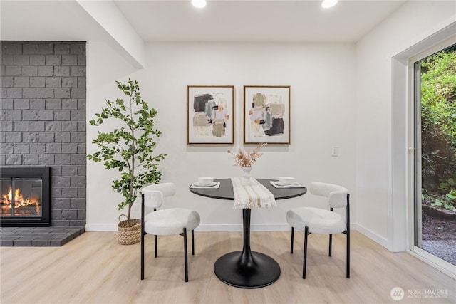 dining area with recessed lighting, baseboards, wood finished floors, and a fireplace