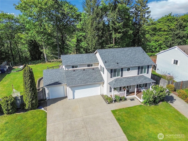 traditional-style home with a front lawn, fence, covered porch, roof with shingles, and concrete driveway