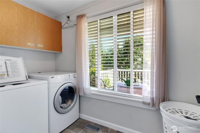 washroom featuring visible vents, cabinet space, washing machine and dryer, and a wealth of natural light