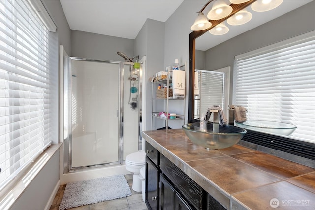 bathroom featuring toilet, tile patterned floors, a shower stall, and vanity