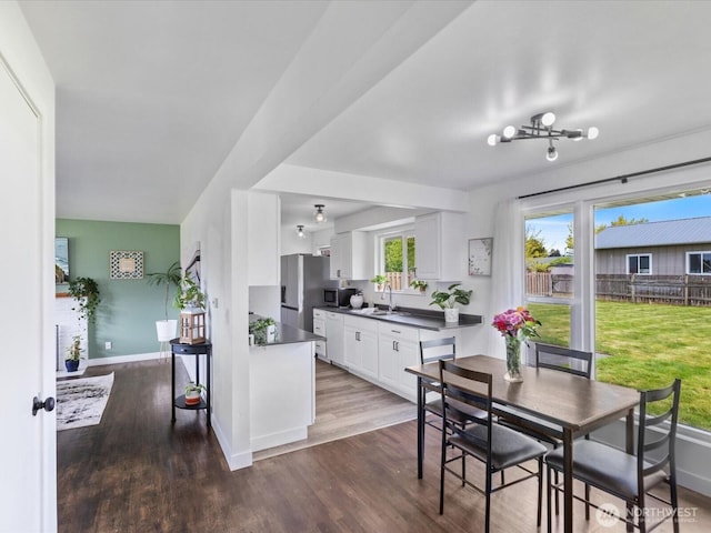 kitchen with a sink, dark countertops, white cabinets, and dark wood finished floors