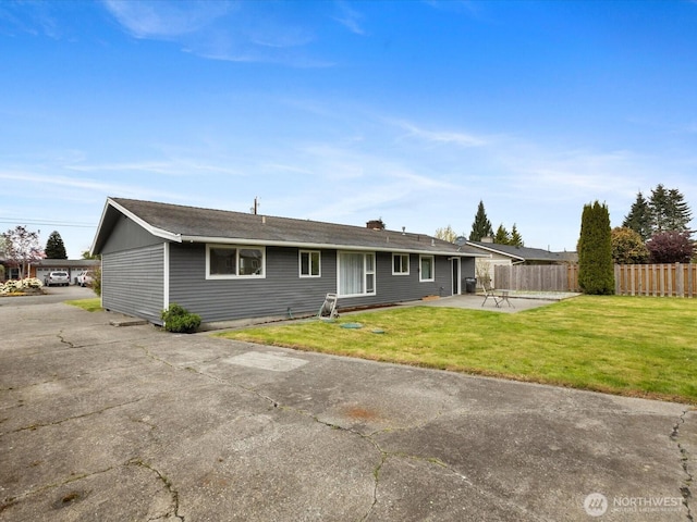 back of house featuring a lawn, fence, and a patio area