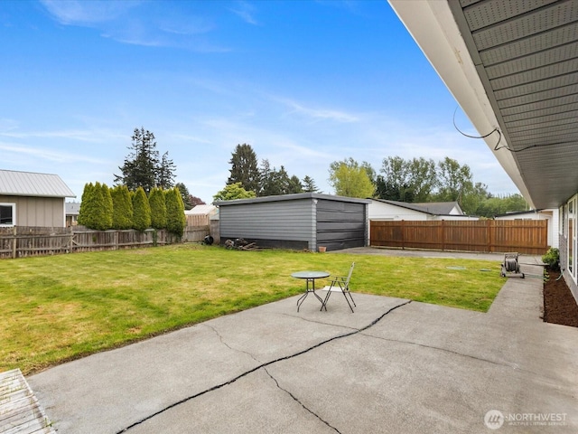 view of patio / terrace with an outbuilding, a fenced backyard, and a garage