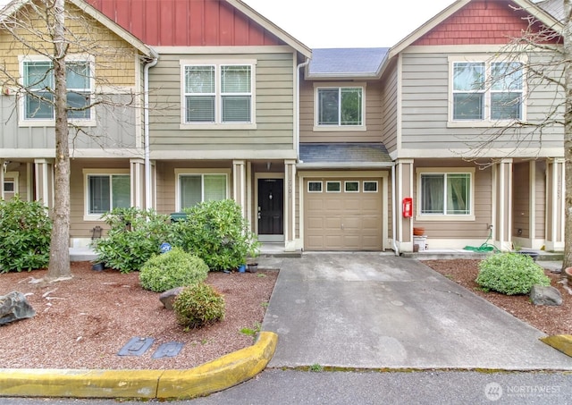 townhome / multi-family property with board and batten siding, an attached garage, and driveway