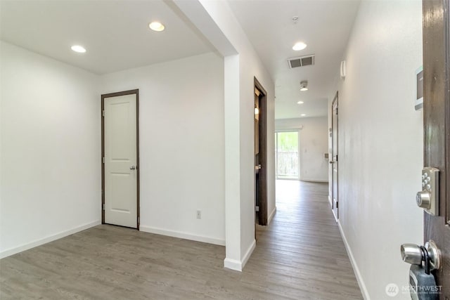 hall featuring baseboards, recessed lighting, light wood-style flooring, and visible vents