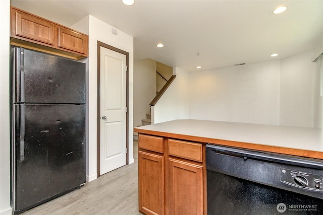 kitchen with light wood-style floors, light countertops, brown cabinetry, recessed lighting, and black appliances