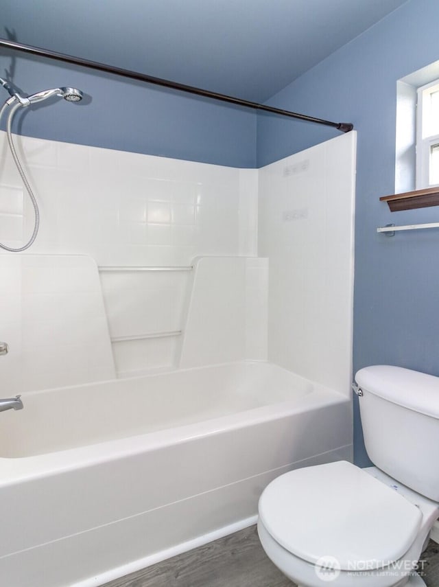 bathroom with toilet, wood finished floors, and shower / bathing tub combination