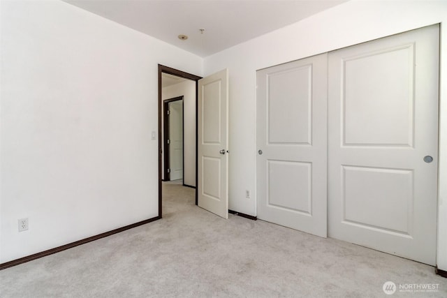 unfurnished bedroom with a closet and light carpet
