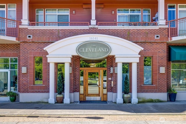 entrance to property featuring brick siding