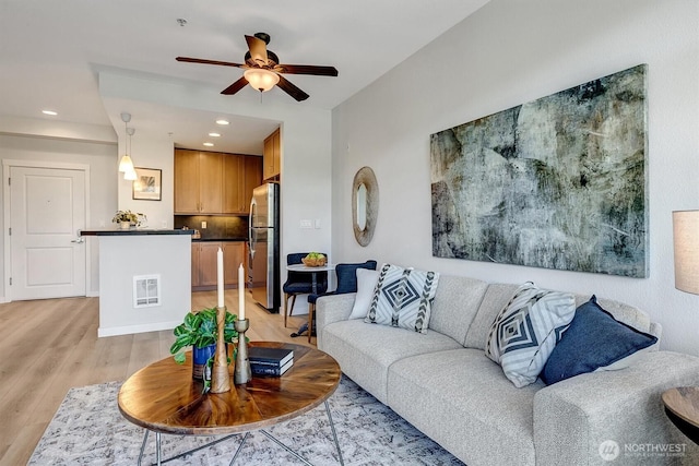 living area featuring light wood-type flooring, visible vents, ceiling fan, and recessed lighting