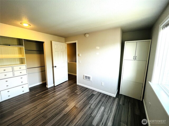 19573 2nd Ave NE, Poulsbo, WA 98366 - unfurnished bedroom with a closet, baseboards, dark wood-style floors, and a textured ceiling