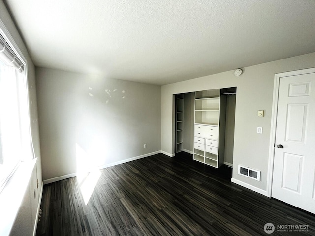 19573 2nd Ave NE, Poulsbo, WA 98366 - unfurnished bedroom with baseboards, dark wood finished floors, a closet, and a textured ceiling