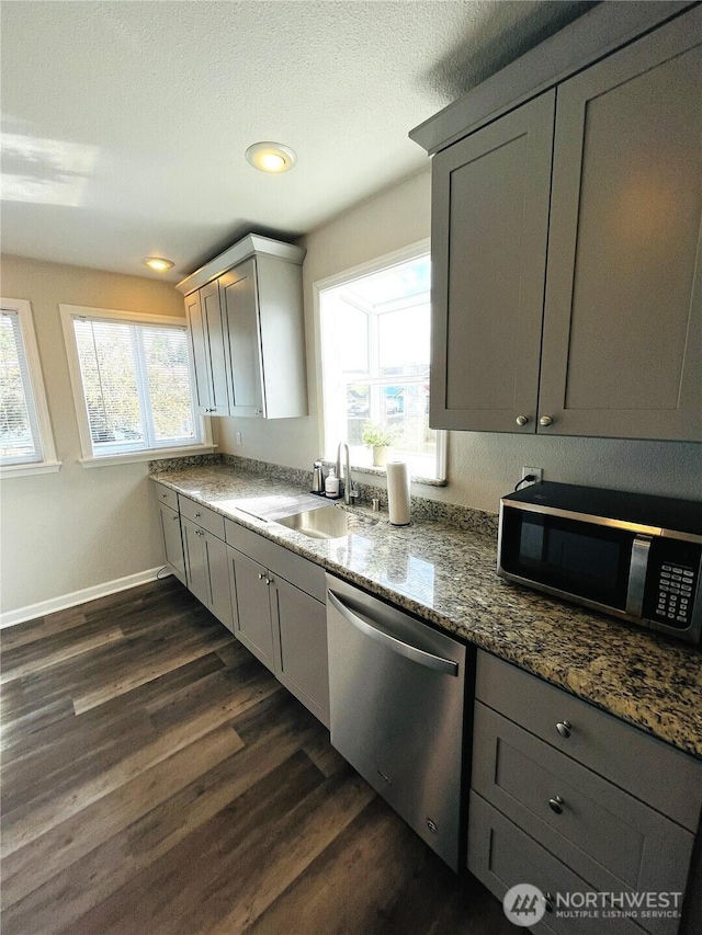 19573 2nd Ave NE, Poulsbo, WA 98366 - kitchen with stainless steel dishwasher, black microwave, a sink, gray cabinetry, and dark wood-type flooring