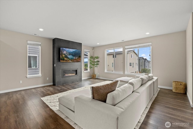 living room featuring recessed lighting, baseboards, wood finished floors, and a tile fireplace