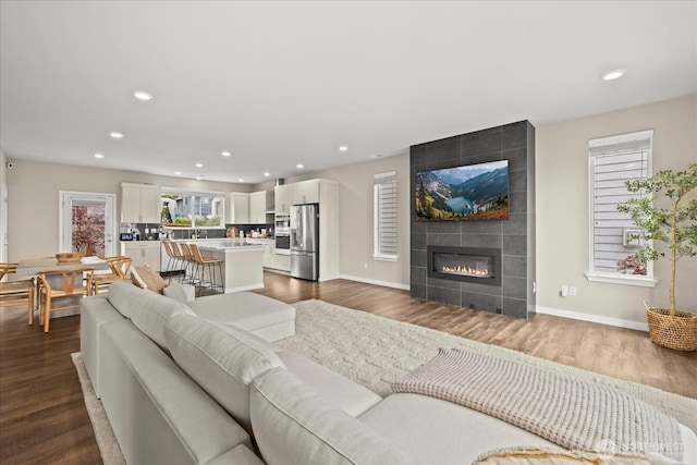 living area featuring dark wood finished floors, baseboards, and recessed lighting