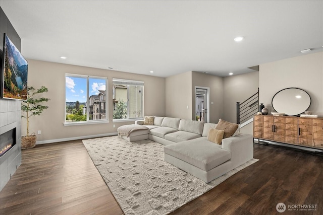 living room featuring a fireplace, recessed lighting, baseboards, wood finished floors, and stairway