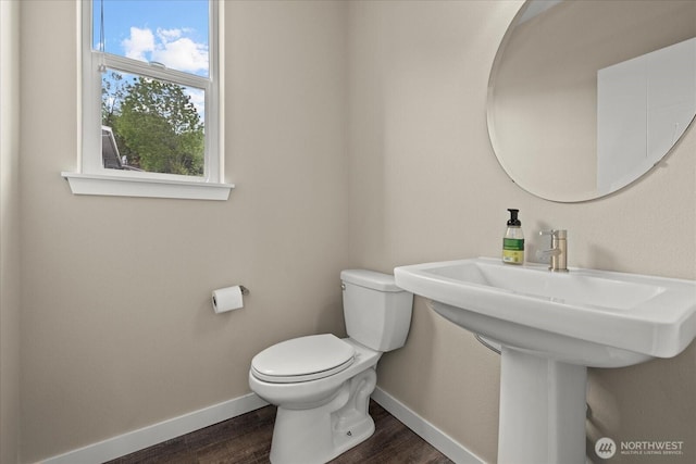 bathroom with baseboards, toilet, and wood finished floors