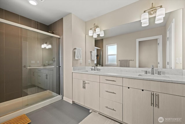 bathroom featuring a sink, tile patterned flooring, a shower stall, and double vanity