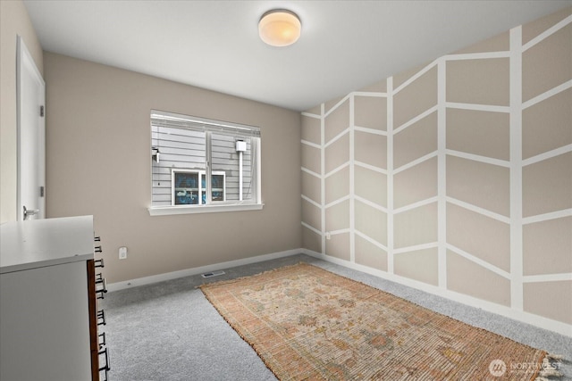 carpeted empty room featuring baseboards and visible vents