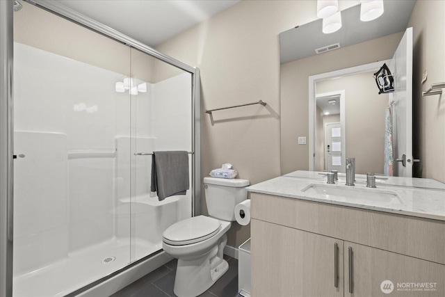 bathroom featuring tile patterned flooring, vanity, toilet, visible vents, and a stall shower